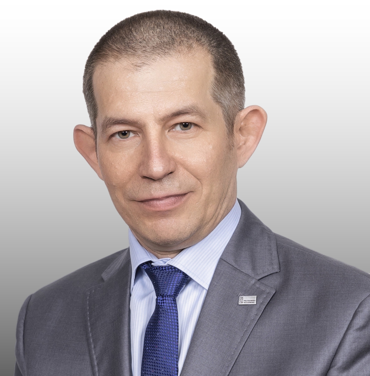 Portret Profesora Bartosza Millera na tle białej ściany