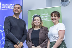 Na tle roll up'ów Politechniki Rzeszowskiej i Zakładu Urbanistyki i Architektury uśmiechają się do zdjęcia Maciej Franta, Anna Sikora i Joanna Dudek.