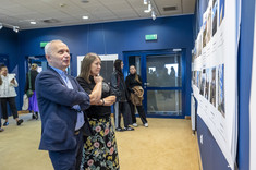 Mężczyzna w ciemnym garniturze i kobieta przyglądają się wystawie. W tle inni uczestnicy wystawy. Na zdjęciu na pierwszym planie: prof. M. Piekarski i dr. W. Kokoszka.