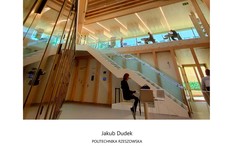 Wnętrze budynku, ludzie siedzą przy stolikach i pracują