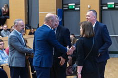 Na sali wykładowej grupa pięciu osób, czterech mężczyzn i kobieta podczas przywitania. Wszyscy oficjalnie ubrani. W tle uczestnicy wykładu. Od lewej: D. Urbanik, Prezydent M. Rzeszowa K. Fijołek, prof. L. Lichołai, prof. P. Nazarko, dr. arch. J. Dudek.