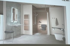 Na zdjęciu ekran z wyświetloną prezentacją. Na slajdzie widoczne wnętrze łazienki utrzymane w jasnych kolorach.