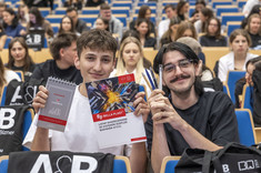 Studenci prezentują część podarków z pakietów wydarzeniowych od sponsorów wykładu.