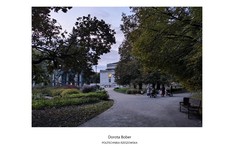 Wijąca się alejka w parku prowadząca do białego zabytkowego budynku