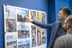 Damian Pękalski wskazuje z zainteresowaniem na jedną z prezentowanych fotografii