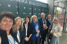 Kilka osób, w tym pracownicy Wydziału Budownictwa, Inżynierii Środowiska i Architektury: dr hab. inż. Bożena Babiarz, prof. PRz, dr inż. Joanna Krasoń, prof. dr hab. inż. Lech Lichołai, dr inż. Przemysław Miąsik na tle baneru Politechniki Białostockiej