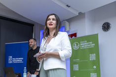 Małgorzata Tomczak zaprasza na wykład. W tle jej postaci Maciej Franta.