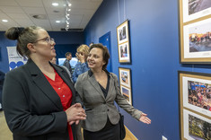 Od lewej: mgr Joanna Makar-Płaza, dr inż. Beata Walicka-Góral uśmiechają się do siebie stojąc przy fotografiach wiszących na ścianie, fot. Beata Motyka
