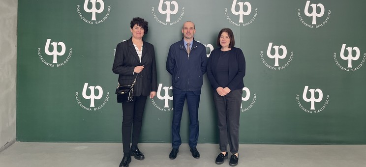 Od lewej: dr hab. inż. Bożena Babiarz, prof. Uczelni, dr inż. Przemysław Miąsik, dr inż. Joanna Krasoń na tle ścianki reklamowej Politechniki Białostockiej.