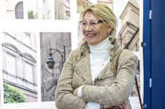 Prodziekan Marzena Kłos z uśmiechem patrzy na prezentowane fotografie