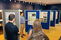 Prezentacja posteru pracy pt. "Analiza awaryjności sieci wodociągowej w wybranym mieście" przez autora mgr. inż. Macieja Pastułę.