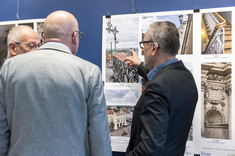 Profesor Aleksander Kozłowski wskazuje z zainteresowaniem na jedną z prezentowanych fotografii