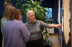 Pani Agata opowiada o jednym ze swoich haftów, który zdobi białą serwetę