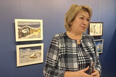 Pani Profesor Galina Kalda opowiada o swoich obrazach. Stoi na tle niebieskiej ściany, fot. dr inż. arch. Joanna Dudek