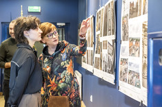 Karolina Kozłowska pracownik WBIŚiA wskazuje z zainteresowaniem na jedną z prezentowanych fotografii, Emilia Łobaza studentka PRZ z zainteresowaniem patrzy na tą fotografię