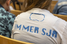 Studentka słuchająca wykładu. Ubrana w koszulkę z napisem Immersja.