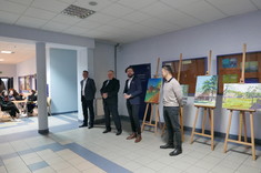 Przemówienie dr. inż. arch. Cezarego Szpytmy, na pierwszym planie od lewej: dr hab. inż. Piotr Nazarko, prof. Uczelni - Prodziekan ds. Rozwoju, prof. dr hab. inż. Lech Lichołai - Dziekan WBIŚiA, dr inż. arch. Cezary Szpytma, dr inż. arch. Igor Labuda. W tle prace malarskie studentów: Michała Bubenko, Moniki Szyszki, Wiktorii Niemczyk, Jakuba Licaka, fot. mgr inż. arch. Beata Raś.