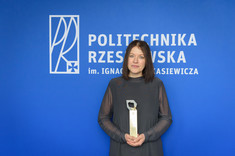 Dr inż. Joanna Krasoń pozuje do zdjęcia na tle niebieskiej ściany, fot. Arkadiusz Surowiec