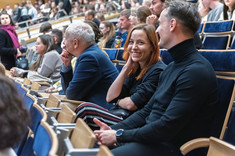 Zbliżenie na słuchaczy wykładu siedzących w rzędach.