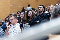 Zbliżenie na uczestników wykładu siedzących w rzędach.