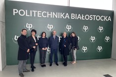 Uczestnicy pierwszego spotkania roboczego w ramach projektu, który uzyskał finansowanie Ministerstwa Edukacji i Nauki w konkursie „Iskra – budowanie międzyuczelnianych zespołów badawczych” Politechniczna Sieć VIA CARPATIA na tle ścianki reklamowej Politechniki Białostockiej.