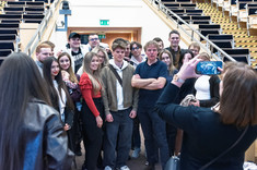 Zdjęcie grupowe studentów, około dwudziestu osób, młodych mężczyzn i kobiet. Po środku wykładowca, starszy mężczyzna ubrany na czarno. Wszyscy się uśmiechają. W tle wyjście z sali wykładowej. Prof. arch. W. Maas i studenci Politechniki Rzeszowskiej.