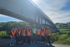 Studenci kierunku transport na tle mostu drogowego w Sielnicy