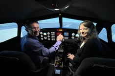 Dwoje przedstawicieli zespołu projektu „Iskra - budowanie międzyuczelnianych zespołów badawczych" „Politechniczna Sieć VIA CARPATIA im. Prezydenta RP Lecha Kaczyńskiego" w symulatorze lotów.