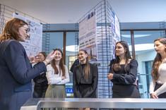 Sześć rozmawiających ze sobą uczestniczek i autorek prac w ramach wystawy prac studenckich, wykonanych w ramach zajęć Projektowanie architektoniczne – usługi II