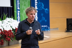 Mężczyzna ubrany na czarno podczas prowadzenia wykładu. Prof. arch. W. Maas, MVRDV.
