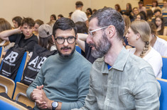 Słuchacze wykładu dyskutujący o prezentacji.