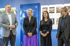 Cztery osoby: dwóch mężczyzn po bokach i po środku dwie kobiety stoją obok siebie. Mężczyzna po lewej przemawia. W tle plansza ze zdjęciami. Na zdjęciu od lewej: prof. P. Nazarko, prof. M. Kłos, arch. A. Pomykała, arch. W. Matłok - prezes SARP o/Rzeszów.