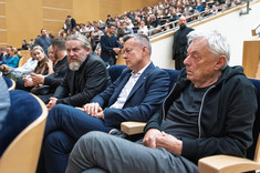 Duża grupa osób na sali wykładowej. Na pierwszym planie siedzi koło siebie trzech mężczyzn. Na pierwszym planie od prawej: arch. W. Fałat, prof. J. Strojny, arch. W. Matłok, prezes SARP O/Rzeszów.