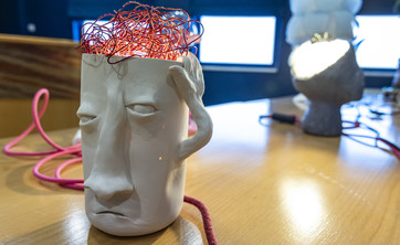 Jedna z lamp wykonanych przez uczestniczkę konkursu w kształcie głowy z której wystają kable przypominające kłębiące się myśli